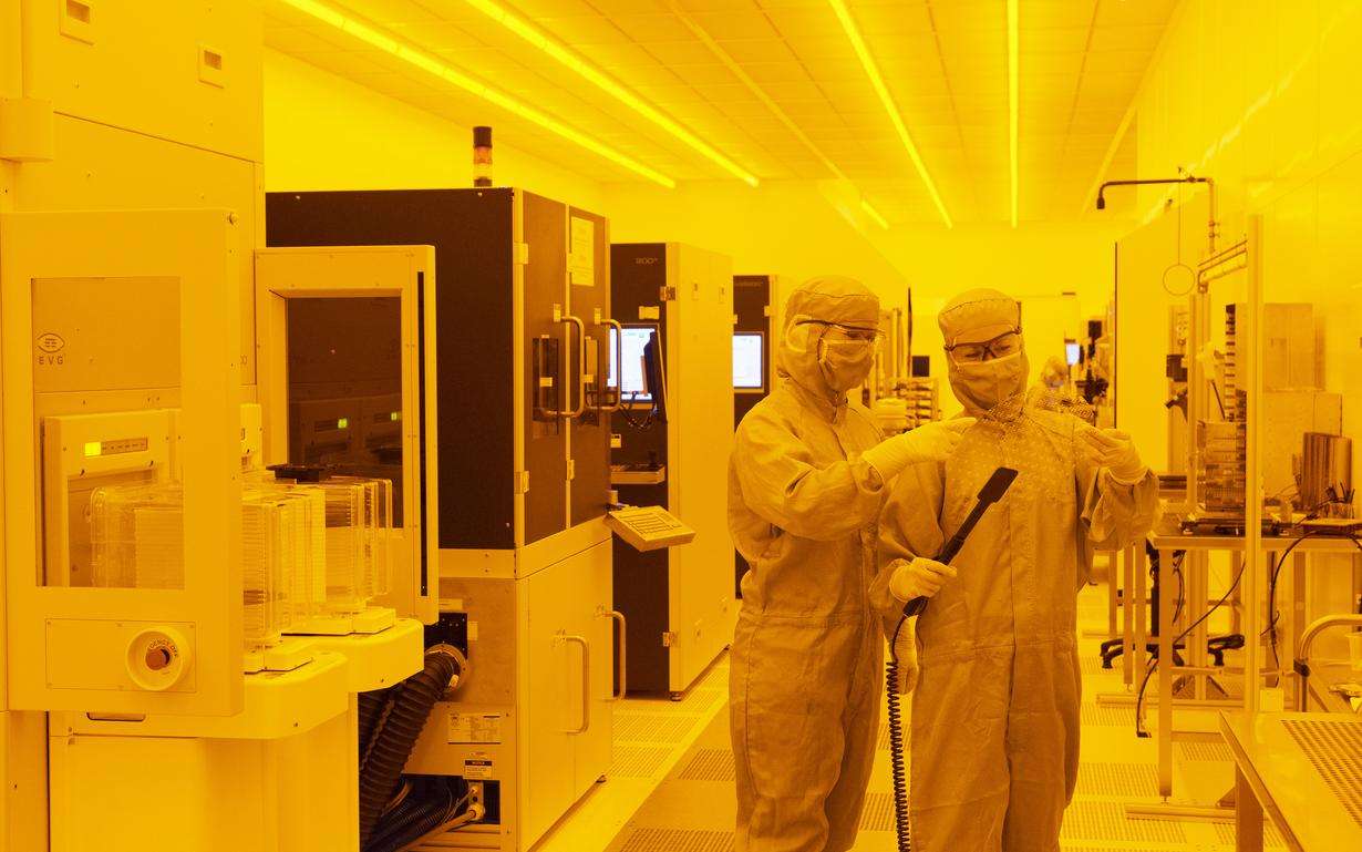 Two process engineers inspect an AR wafer in the lab