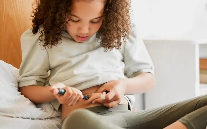 Young child self-injects medication using an autoinjector 