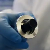 A hand holding a spectrometer probe head with SCHOTT SmartNut™