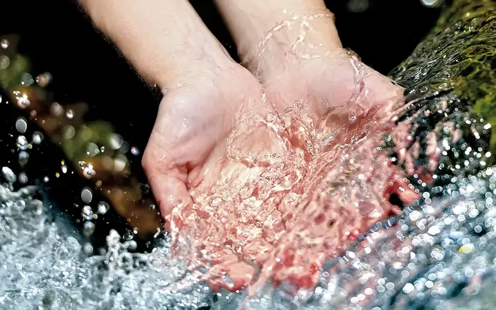 Two hands under flowing water