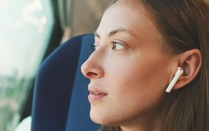 Woman listening to a Pharmaversity® podcast on the train