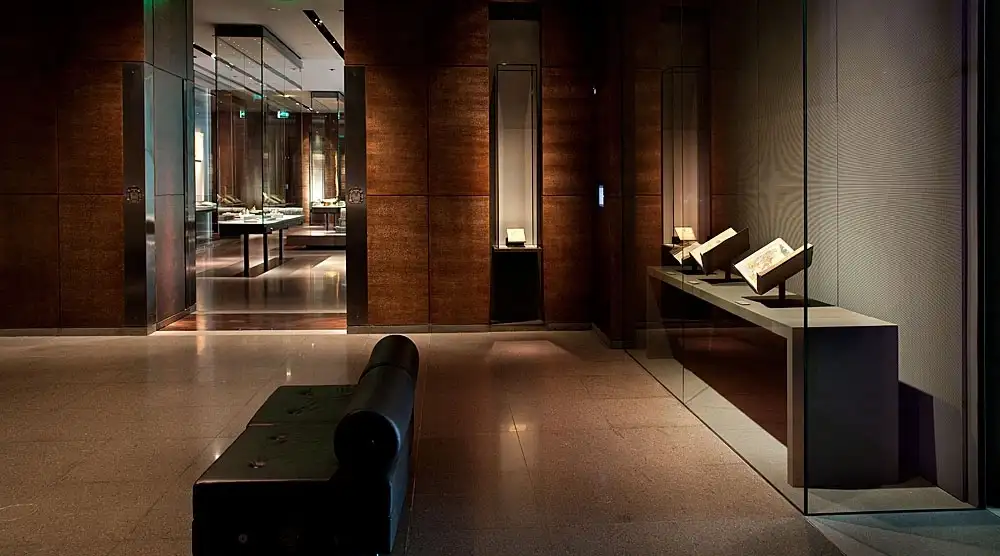 	Interior of the Museum of Islamic Art in Doha, Qatar, with chairs and glass display cases