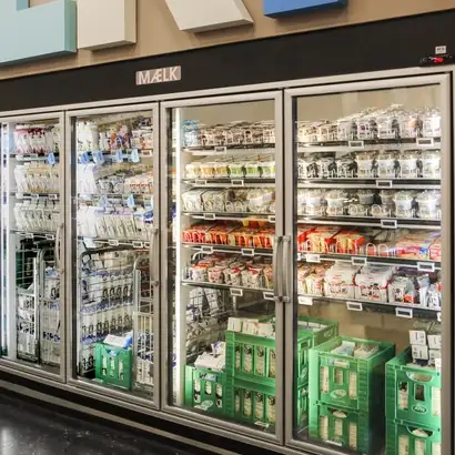 Row of chiller cabinets filled with dairy products in a Cold Room fitted with SCHOTT Termofrost® glass door systems