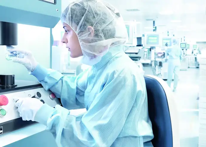 Female scientist inspects a glass vial in a laboratory