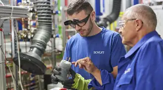 Two SCHOTT employees in blue work gear in the electrochemistry lab