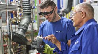 Two SCHOTT employees in blue work gear in the electrochemistry lab