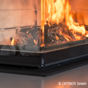 Close up of indoor fireplace with SCHOTT ROBAX® angular bent fire-viewing panel