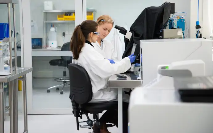 Two scientists examine a sample in a laboratory