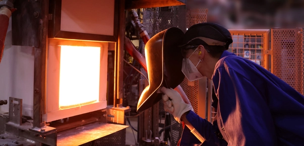 A glass scientist looks into a melting tank.