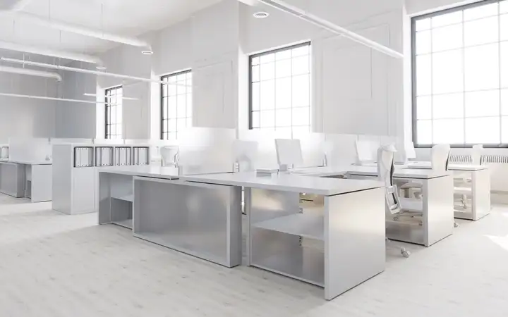 White open plan office with series of desks with glass desk dividers