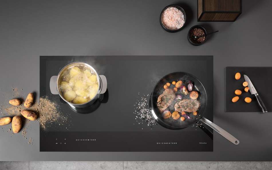 Top view of a kitchen cooktop with pans of food cooking