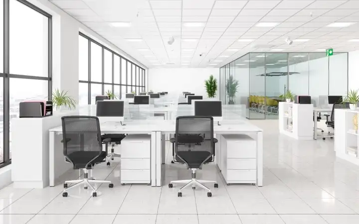 Interior of an office, with glass partitions and desk dividers