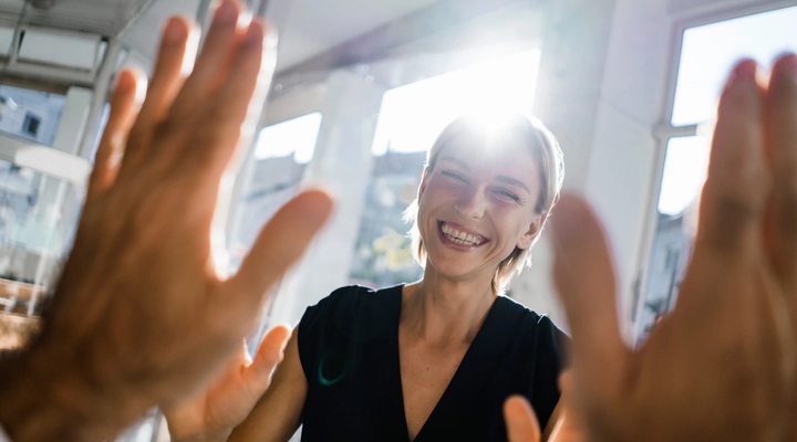 Female and male giving each other high five in an office