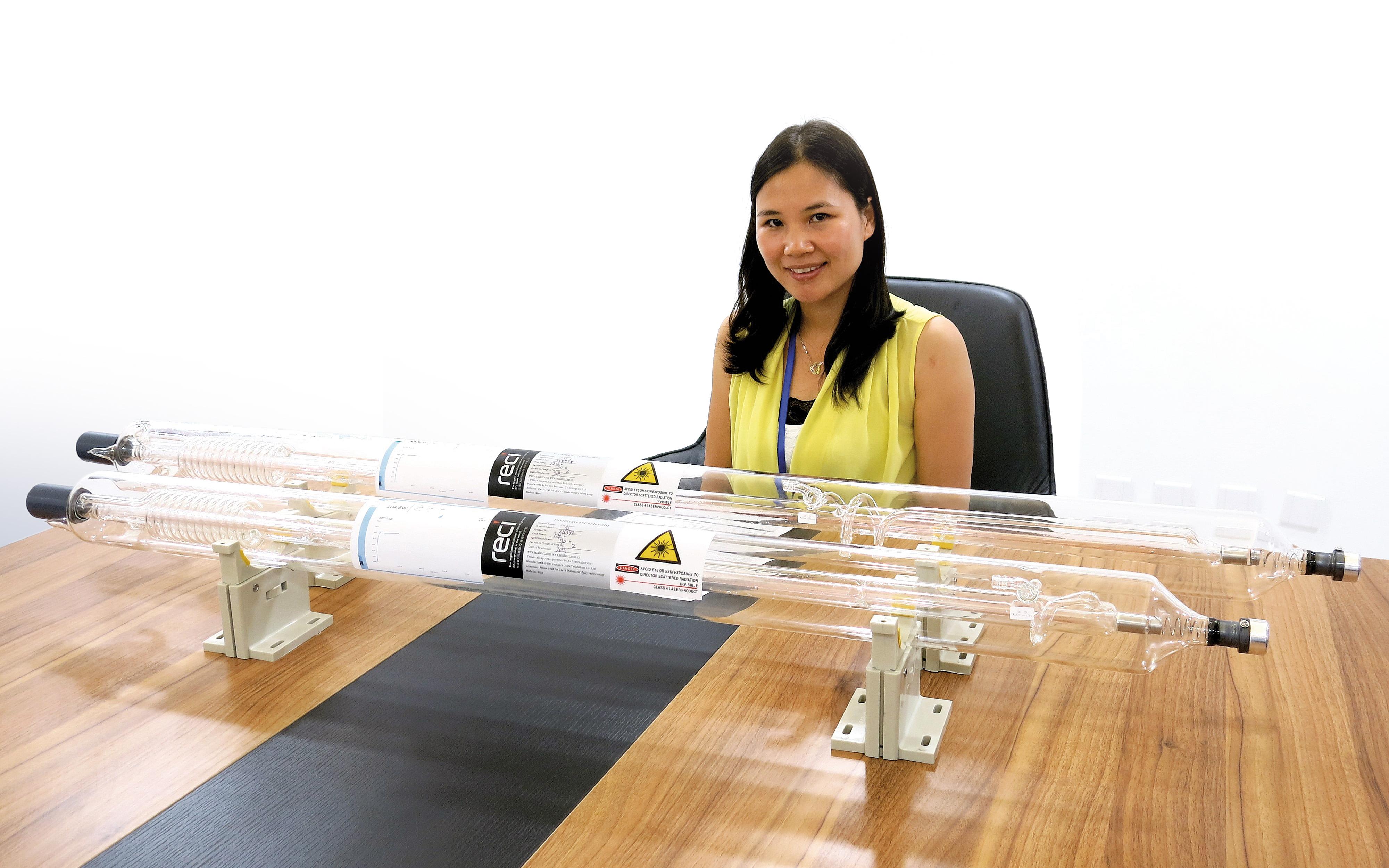 Lu Chundi, General Manager at RECI, sits in front of two DURAN® borosilicate glass tubes for lasers