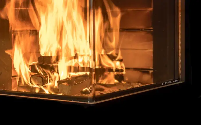  Knisterndes Kaminfeuer hinter einer winklig geformten Feuersichtscheibe