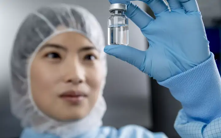 woman looking at glass vial