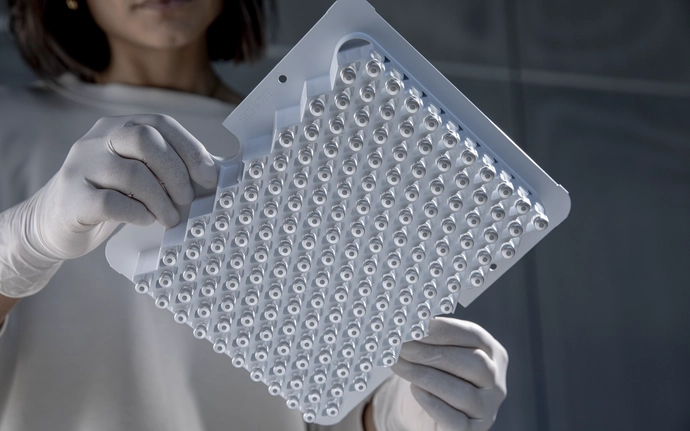 Person wearing gloves holding cartridges in nest design.