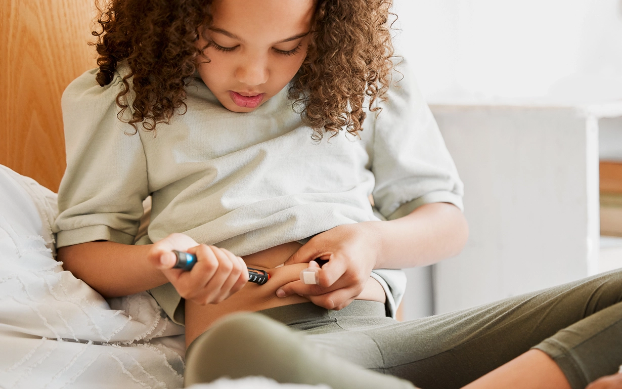 A girl with type 1 diabetes checks her blood glucose levels