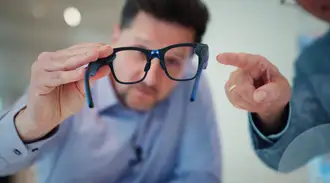 Man holds AR glasses in his hands and looks through them.