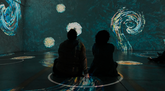 Event projector creating an immersive experience with people sitting and watching swirling star patterns