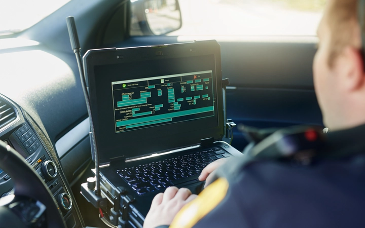 Male security officer wearing augmented reality glasses examining a vehicle