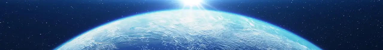 View of Earth from space at sunrise, with glowing city lights visible across continents under a starry sky