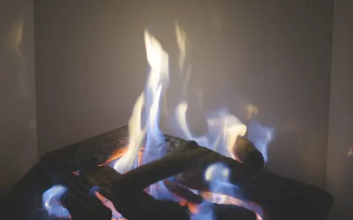 Gas fire with white SCHOTT ROBAX® Magic with Signature Impressions glass-ceramic panels in the background