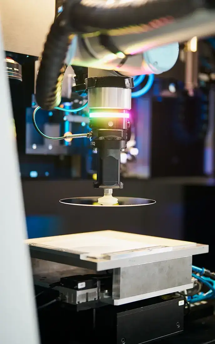 Cobot positioniert einen Glaswafer in einer Laserbearbeitungsmaschine