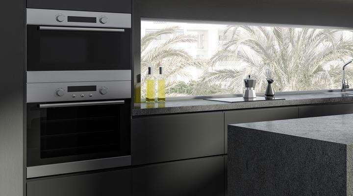 Sleek dark modern domestic kitchen with a range of appliances