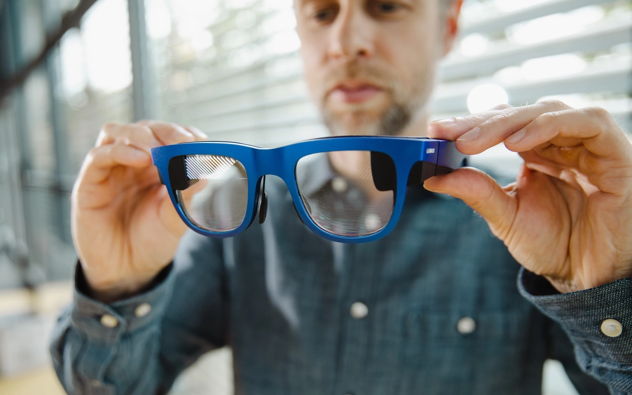 Man holding AR glasses in his hand.