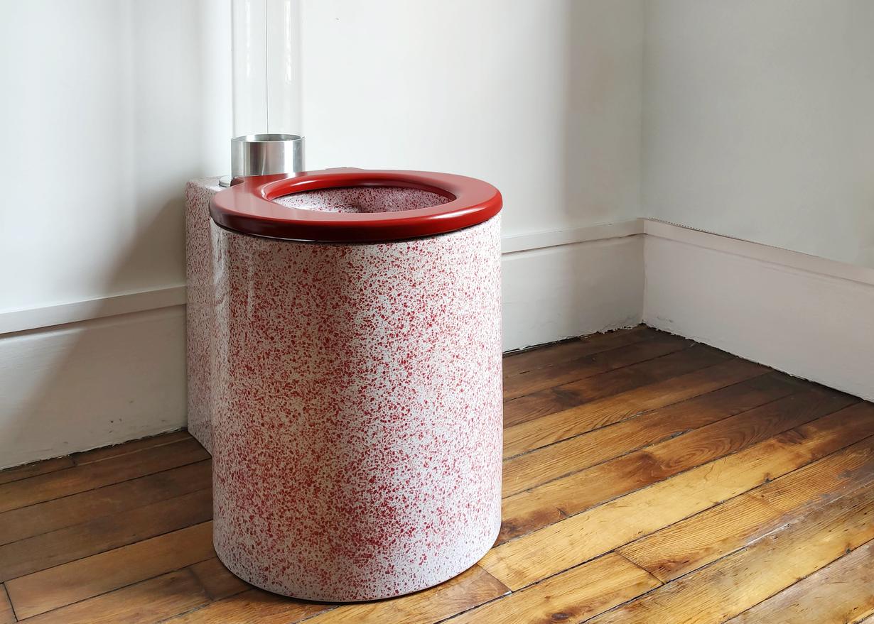 A toilet designed by French designer Trone featuring a glass tube made of DURAN® Tough 