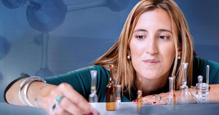 Woman with glass molecule looking at ampoules in front of her