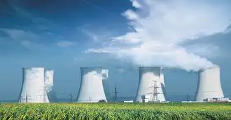 Nuclear power plant with summer field and big blue clouds.