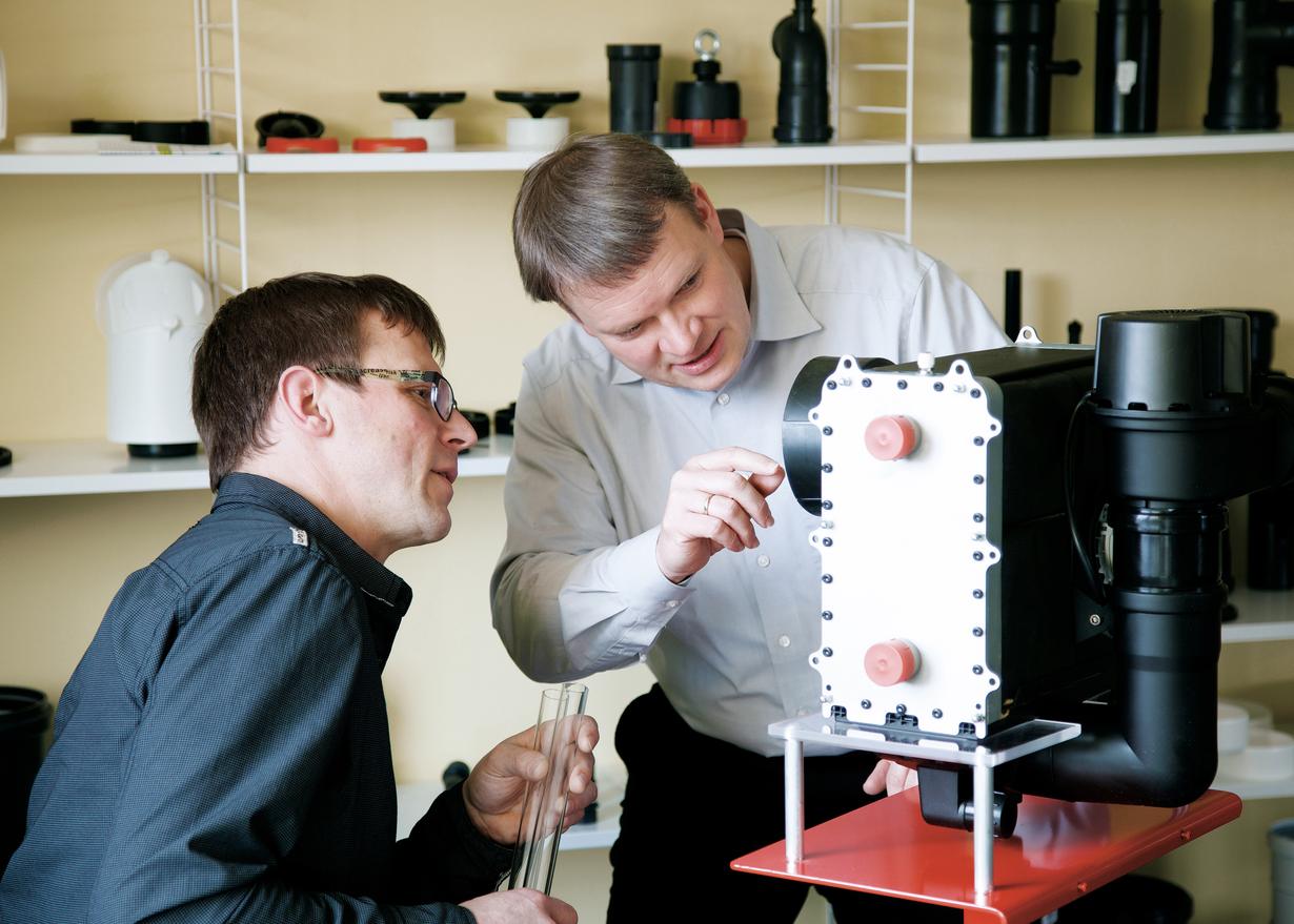 Guido Jobst, director general de ATEC Abgas-Technologie, y un colega examinan un sistema de intercambiador de calor. 