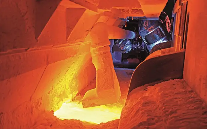 Vista del interior de un depósito de fusión SCHOTT que funciona a temperaturas muy altas y, por lo tanto, brilla en tonos naranjas