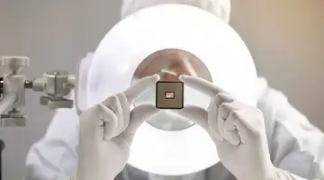 Scientist inspecting miniaturized glass-based semiconductor packaging