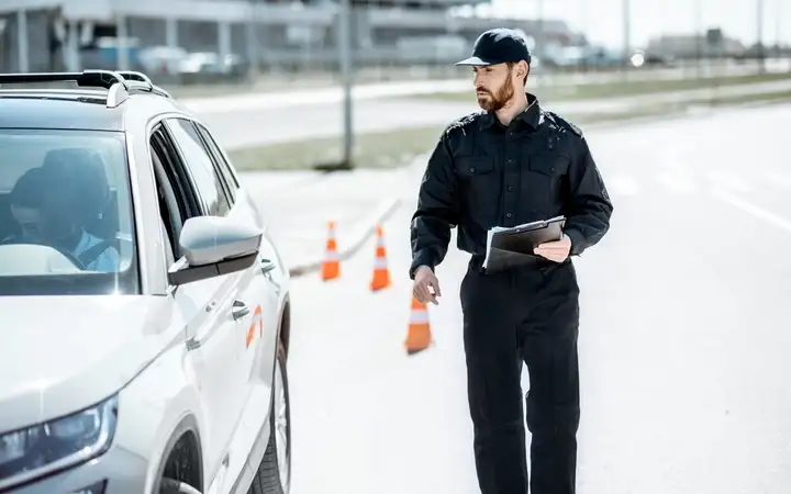 Male security officer wearing augmented reality glasses examining a vehicle