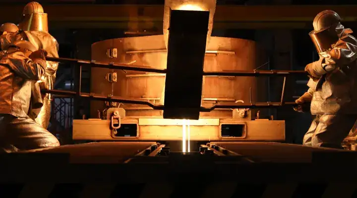 Glass technicians poring molten glass into a mold