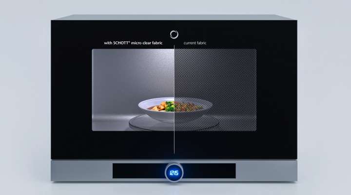 A microwave oven with a split view showing the difference between "SCHOTT® micro clear fabric" on the left side and "current fabric" on the right. The left side is clearer, displaying a plate of food inside, while the right side is more obscured. 