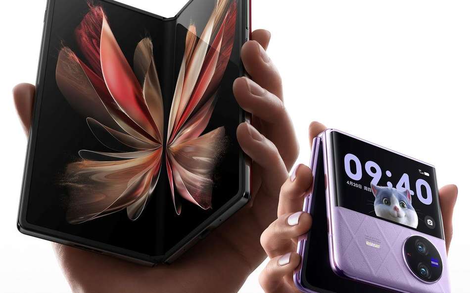 Hands hold two foldable phones.