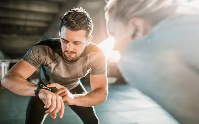 Mann und Frau schauen auf eine Smartwatch 