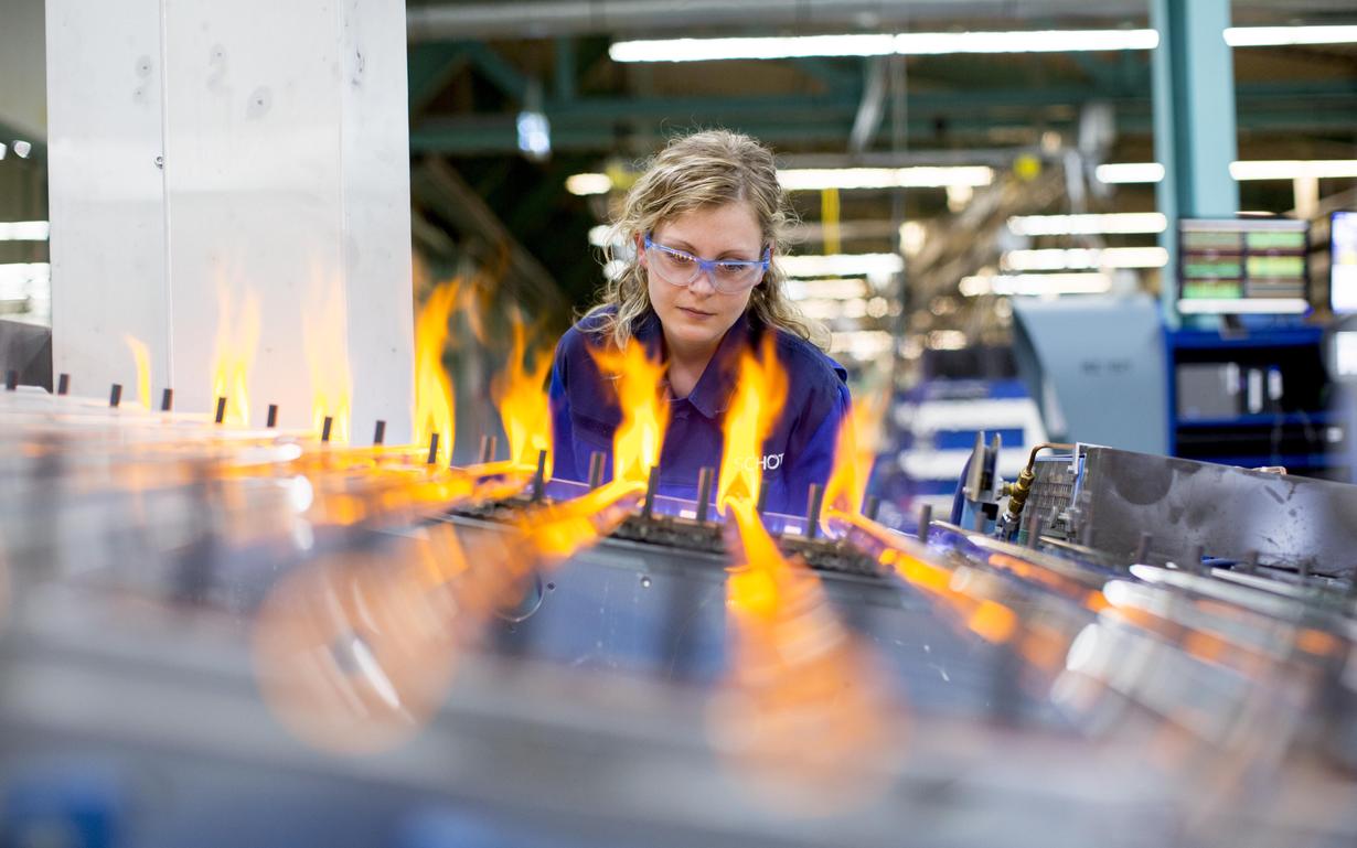 Woman at the plant for tubular glass production