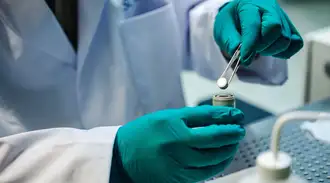 Glass-ceramic powder pressed into tablet form is inserted into a battery model in the lab