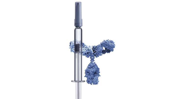 A glass prefillable syringe in front of a sensitive drug molecule.