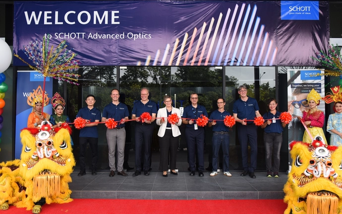 Several people, connected by a symbolic chain, at the opening ceremony in front of the SCHOTT Glass Malaysia building.