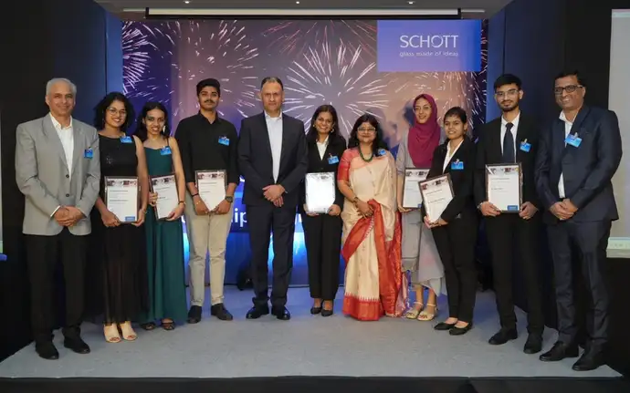Award winners and organizers at a SCHOTT ceremony, holding certificates in a festive setting.