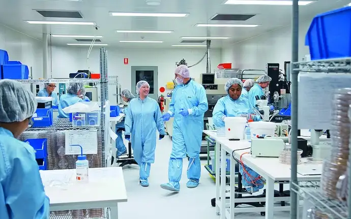 Laboratory workers talking in a cleanroom