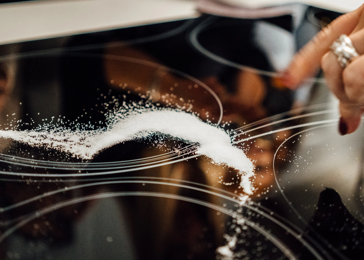 Line of salt on a black glass-ceramic cooktop	