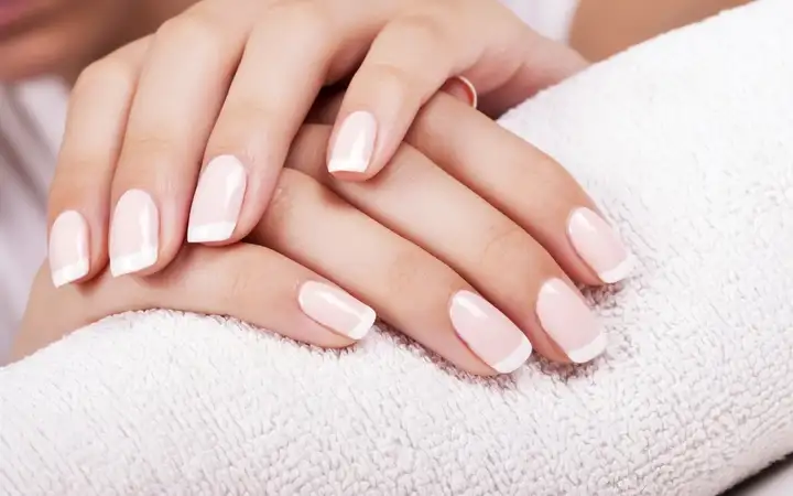 Pair of manicured female hands on a towel