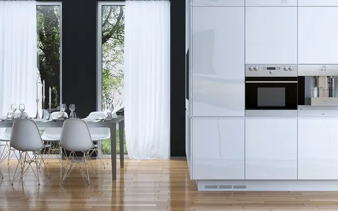 Modern kitchen with row of appliances and table and chairs